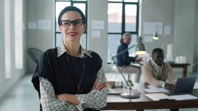 Portrait of beautiful middle age businesswoman standing with arms crossed and smiling at camera at work in architectural office