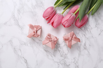 Gift boxes and pink tulips on white marble surface. Romantic, holiday concept