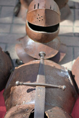 A complete, rusty knight armor with a sword.