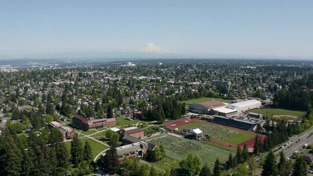 Aerial View Of City Buildings And Graduation Ceremony In The Field Of University Of Puget Sound In Tacoma, Washington.