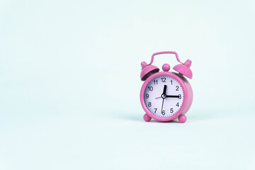 Pink alarm clock on white background