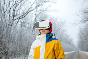 Boy in virtual reality glasses in winter scenery on the road