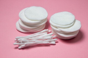 Fototapeta na wymiar Cotton pads and cotton swabs on a pink background. Personal hygiene concept. Cotton wool products
