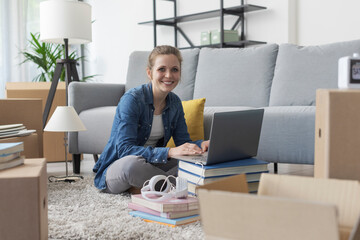 Cheerful woman connecting online in her new home