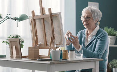 Senior woman painting on canvas