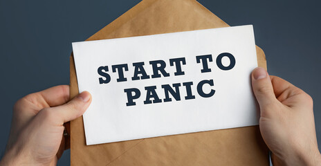 Closeup of a male hands holding craft envelope with text Start to Panic on blue background