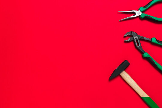 A set of quality green building tools to repair a car or a house on a red background. Do it yourself instruments. Banner for advertising construction shop with copy space. Business card
