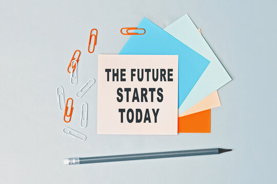 Naklejki The future starts today - text on sticky note paper on gray background. Closeup of a personal agenda. Top view