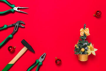A set of quality green building tools to repair a car or house and Christmas tree on a red background. Do it yourself instruments. Banner for a New year advertise construction shop with copy space
