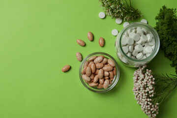 Fototapeta na wymiar Concept of herbal medicine pills on green background, space for text