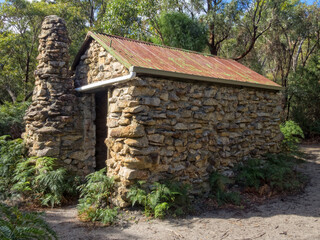 Naklejka premium Halfway Hut along the Telegraph Track is a stone bush hut surrounded by lush coastal vegetation - Wilsons Promontory, Victoria, Australia