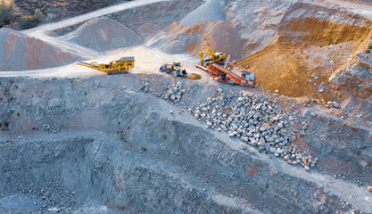 Excavator, bulldozer and conveyor machines on top of stone quarry