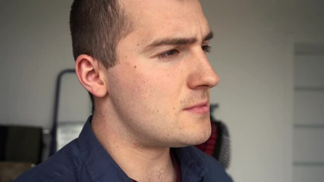 a man in a shirt smokes a cigarette indoors