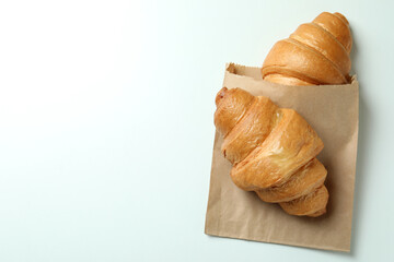 Paper bag with croissants on white background