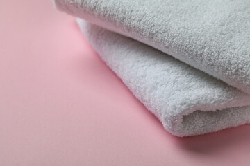 Clean folded towels on pink background, space for text