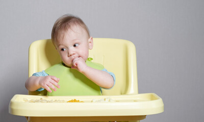 little child eats on gray background