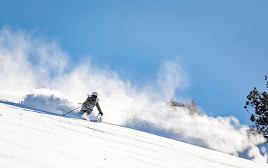 Naklejka na ściany i meble Skier rides on fresh snow against blue sky