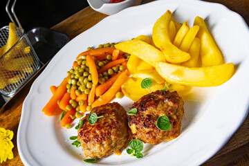 Homemade meatballs with french fries and vegetables