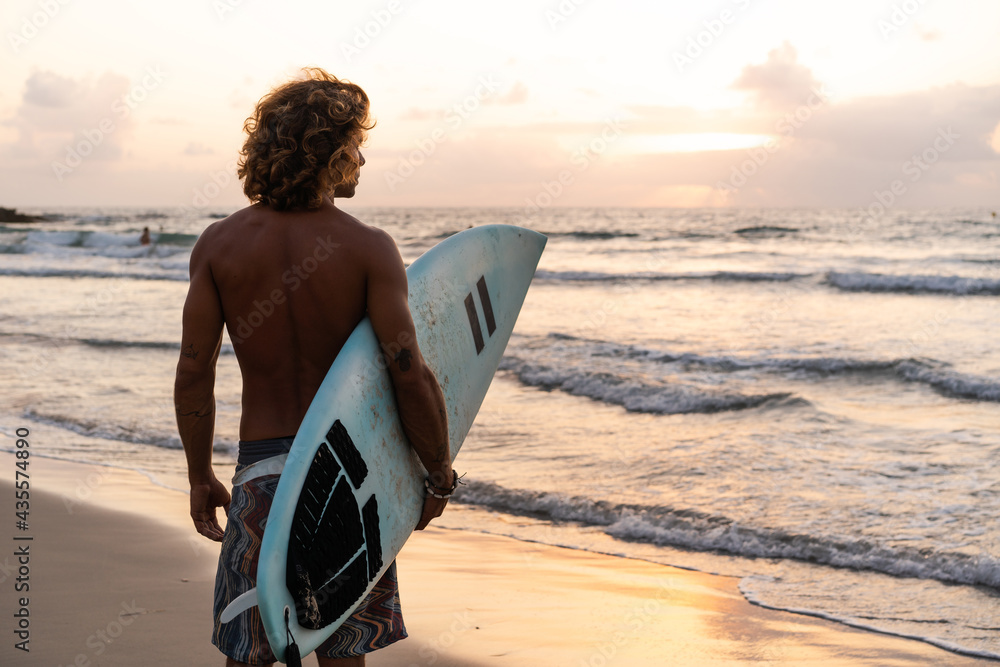 Canvas Prints Young caucasian man get up early to  doing surf at sunrise