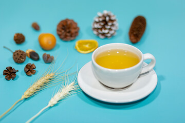 A white teacup on a green table in the living room in the morning.