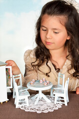 Girl playing with doll's furniture
