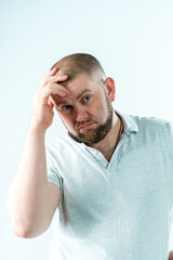 Naklejka premium Beautiful man with beard holds his hand on his head