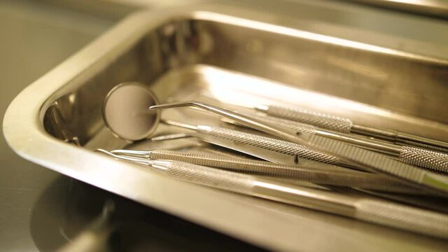 Essential dental sickle cleaning tools lined up in a tray