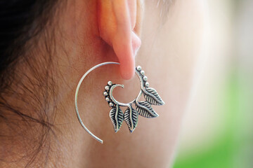 Girl wearing silver plated brass Indian earrings in spiral shape
