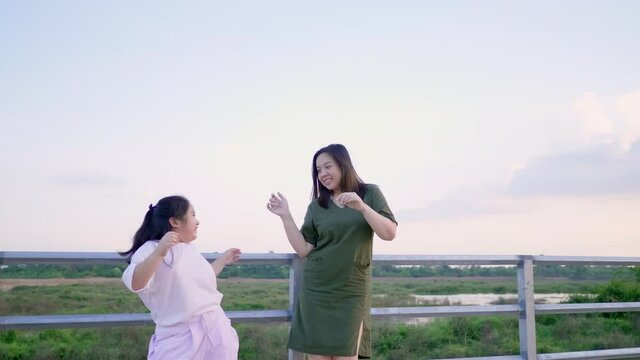 Asian mom and kid are on vacation. Spending time outdoor and dancing together. Happy and having fun. lovely family concept. Asian mom and kid with beautiful nature