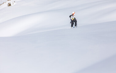 Fototapeta na wymiar Skier walks on fresh snow uphill