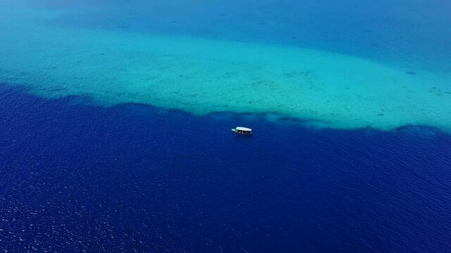 Luxury yacht cruising out at sea. Aerial view of luxury yacht cruising in turquoise lagoon. Aerial drone tracking video of luxury boat. Motor Yacht sailing on open ocean. Tropical. Bahamas and
