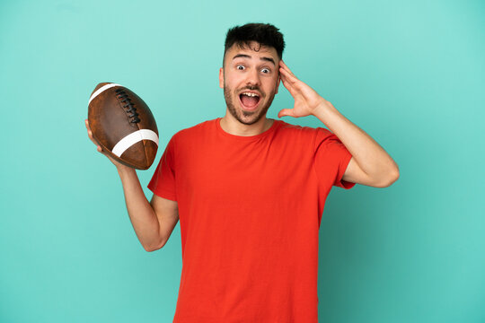 Young Caucasian man playing rugby isolated on blue background with surprise expression