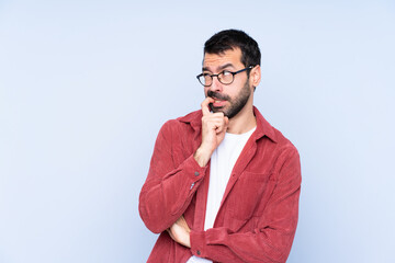 Young caucasian man wearing corduroy jacket over blue background nervous and scared