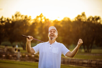 The senior golfer rejoiced at his victory. Man on golf filed.  Great victory.