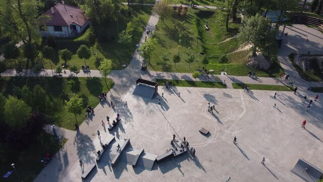 Drone on children playing in the skate park and people walking in the park 