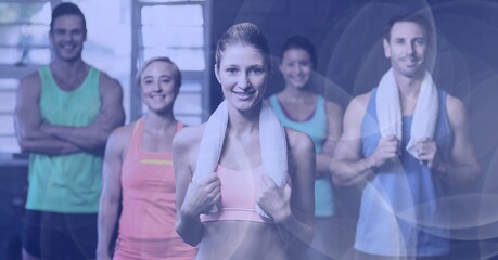 Composition of smiling men and women in fitness class with spot lights