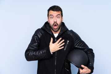 Man with a motorcycle helmet over isolated background surprised and shocked while looking right