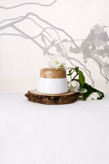 Skin care cream on a white background with apple tree branches.