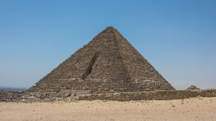 Fototapeta na wymiar Attractions of Egypt. Nomad on camel near pyramids in egyptian desert