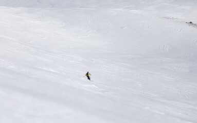 Skier rides on a large snow field in winter