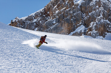 Snowboarder rides on snow in the mountains in winter for heliskiing
