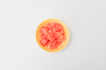 In the plastic bowl is a watermelon cut into pieces