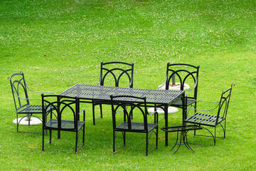 table and chairs in garden on green grass or lawn with no people concept picnic in Summer or...