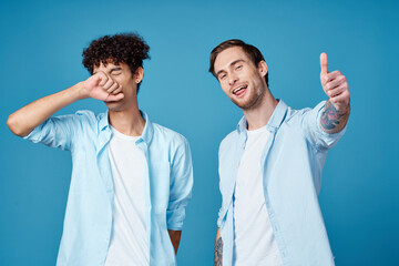 young guys in the same shirts and t-shirts are gesturing with their hands on a blue background friends