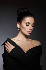 Classic beauty portrait of woman with perfect evening makeup on dark background. Perfect skin without wrinkles, professional beauty makeup, long eyelashes. Perfect girl in black clothes