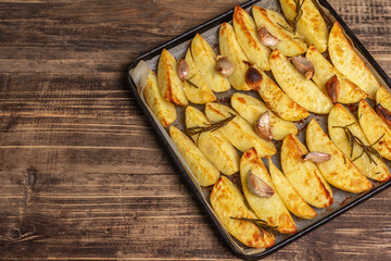 Baked pieces of spiced potato in a baking pan
