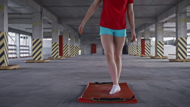 teenaged girs sits down in lotus pose on yoga mat clases her eyes and starts meditating. Doing yoga everywhere.