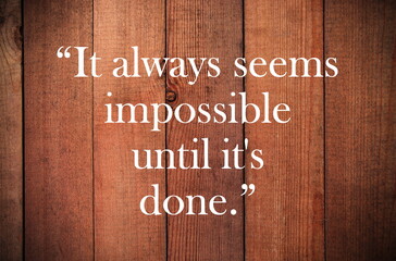 Inspirational quote, motivation. Typography on wooden background. It always seems impossible until...