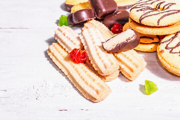 Assorted various cookies and cupcakes scattered on wooden boards background