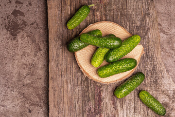 Crispy cucumbers on a wooden stand, marble background